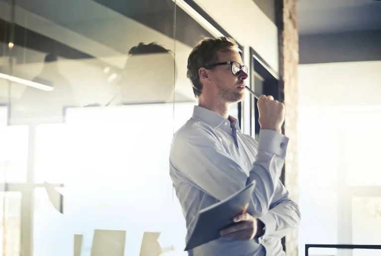 Businessman standing in an office in deep thought